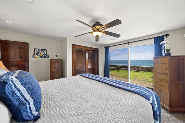 Guest Bedroom 1 has ocean views and sliding doors leading out to the backyard