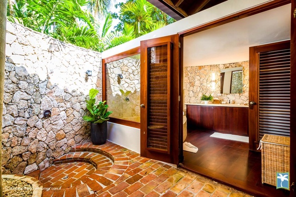 Ensuite bathroom with an outdoor feel and stone walls.