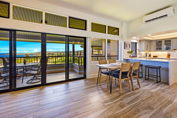 Enjoy your meals with a stunning ocean view from this dining area, featuring floor-to-ceiling windows and easy access to the outdoor lanai