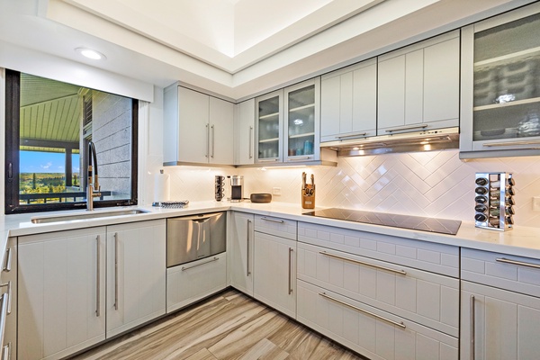 This modern kitchen features sleek cabinetry, stainless steel appliances, and a well-lit countertop to enjoy a comfortable cooking experience.