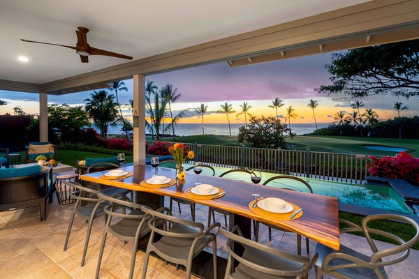 Outdoor dining area overlooking a tranquil pool and ocean at dusk.