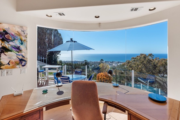 Custom cherry wood desk with amazing ocean views. Privacy screens are used in lieu of window coverings.