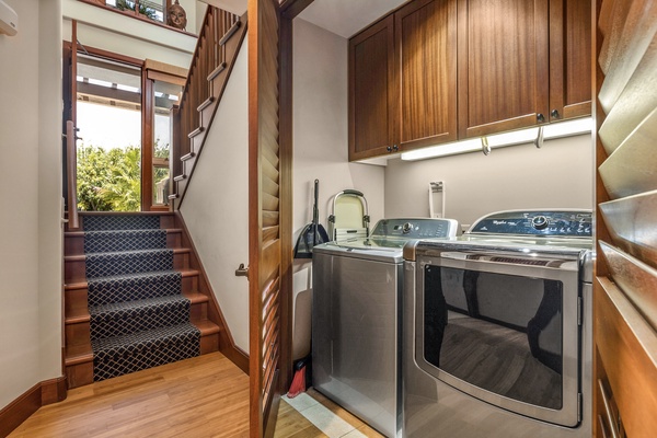 Laundry area with oversized washer and dryer and supplied laundry products.