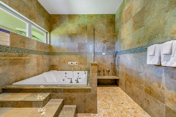 The primary en-suite bathroom with deep soaking tub and walk-in shower.