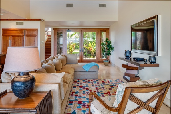 Double Doors from Courtyard Enter into Living Room w/ Plush Sofa and Large Flatscreen TV.