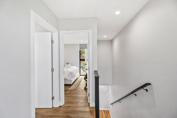 The hallway upstairs with two beds and one bath.