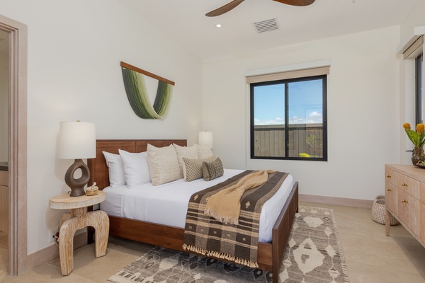 This spacious bedroom is a blend of contemporary design and comfort, featuring a large, inviting bed with crisp white linens and stylish accent pillows.