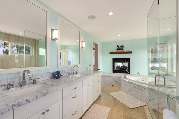 Primary en suite bathroom with see-through fireplace.