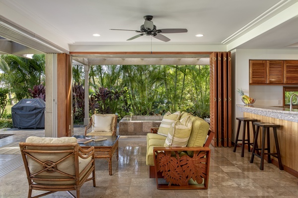 Seating area with open pocket doors on two sides and breakfast bar behind.