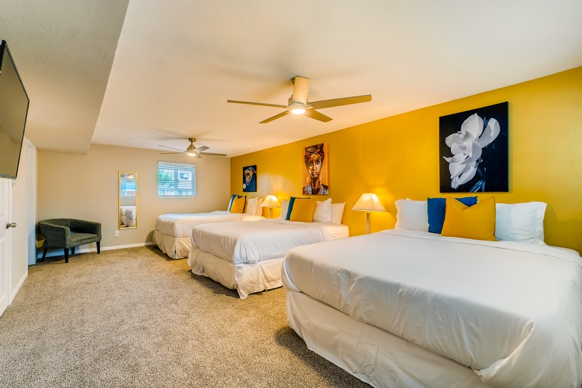 The fourth bedroom is located in the downstairs area and set up with three queen beds and 43" smart TV