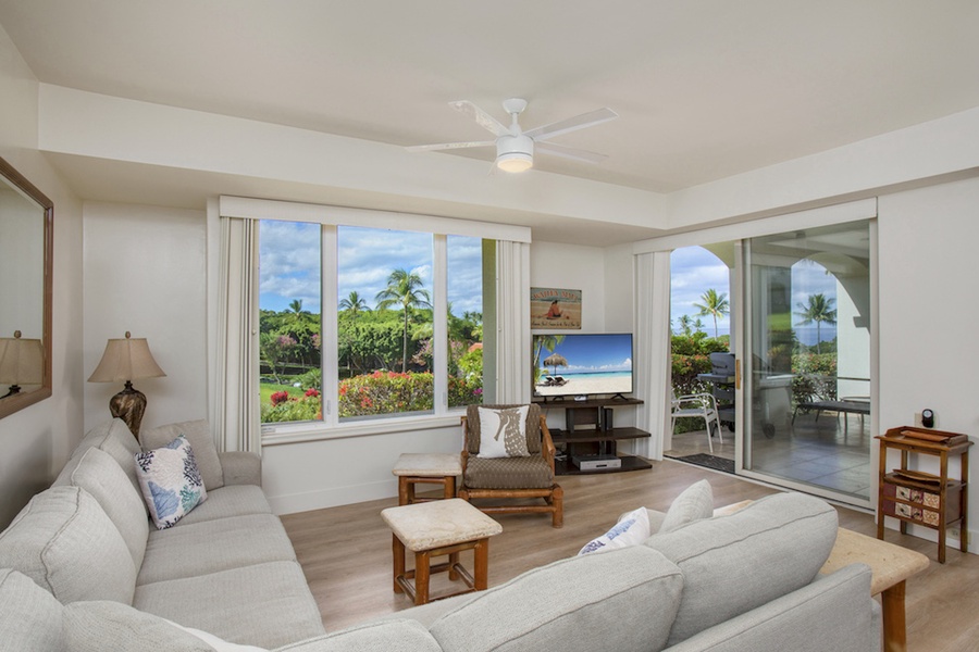 Living room opens to the lanai and bay windows for a tropical vi