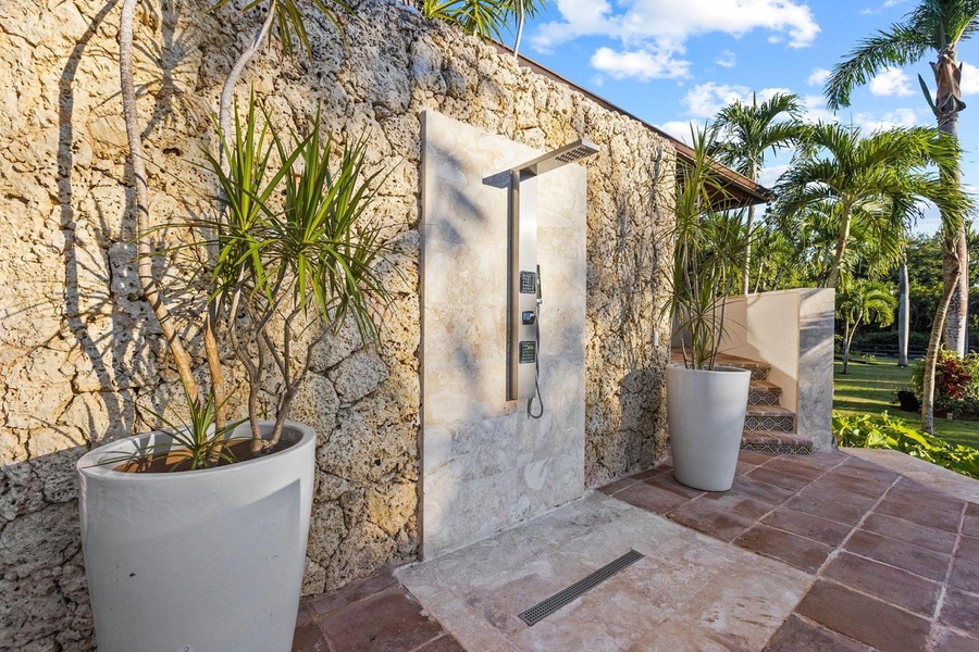 Refresh in this outdoor shower set against a stone wall after a good swim.