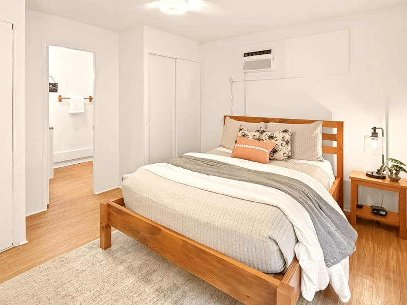 Rest peacefully in your bright, modern bedroom featuring warm wood furnishings and fresh linens that invite sweet dreams.