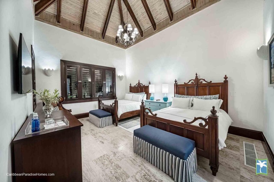 Beautifully designed guest bedroom with classic wooden furnishings and two beds.