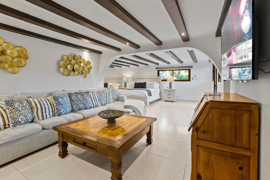 The guest bedroom also features a comfortable sofa with patterned cushions, perfect for relaxation.