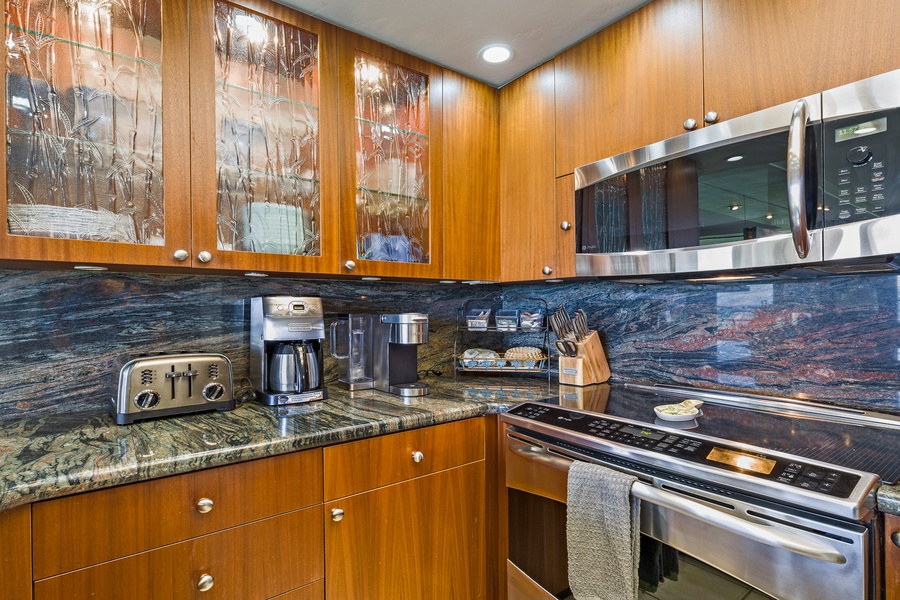 Papakea L-106 offers a full kitchen with modern appliances and sleek wood cabinetry for easy meal prep