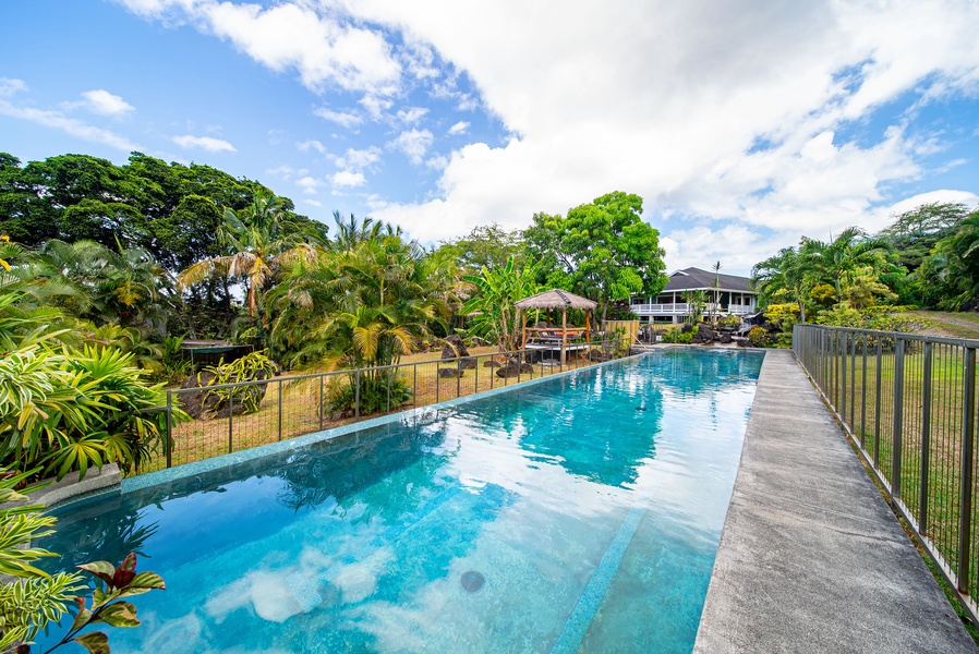 Sparkling private lap-style pool surrounded by lush greenery—perfect for swimming laps or lounging under the island sun.