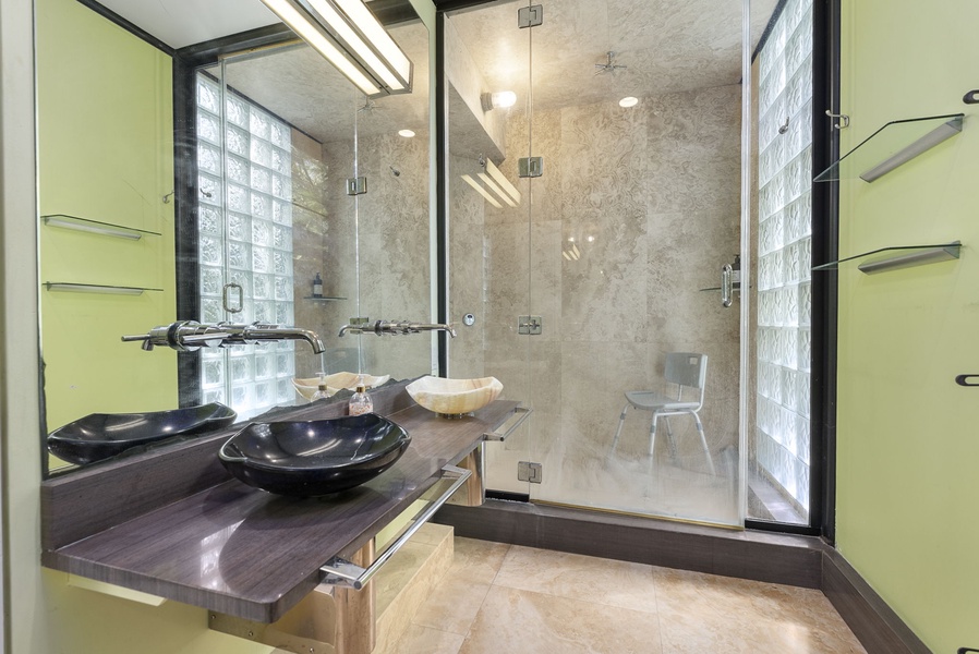 A beautifully designed ensuite with a sleek vanity and a rainfall shower.