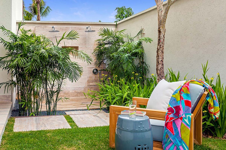 A serene outdoor shower area surrounded by lush greenery, perfect for refreshing moments in nature.