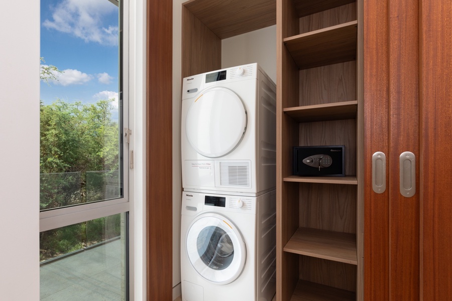 Miele brand stackable washer and dryer set with premium appliances, perfectly placed near Bedroom 4.