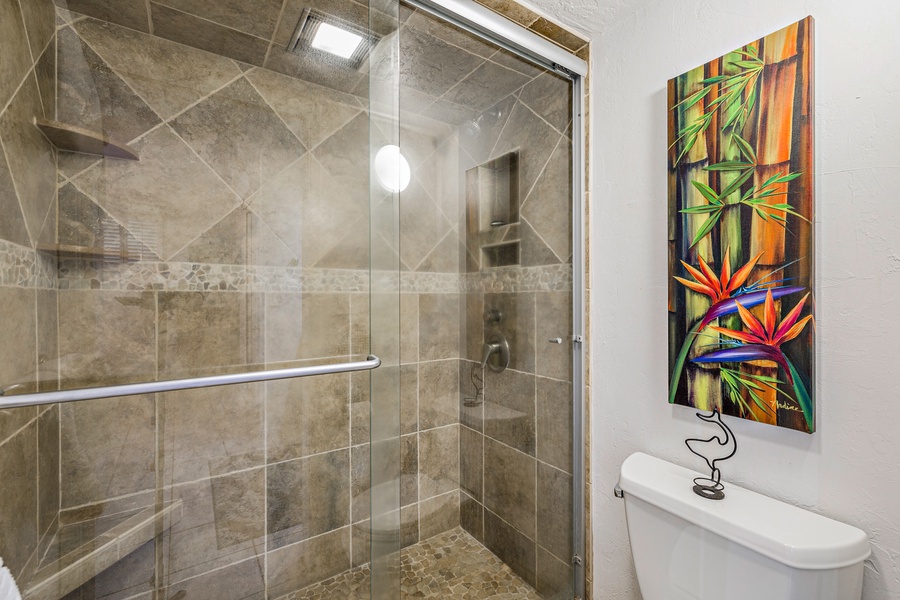 This beautifully tiled walk-in shower offers a spa-like experience with modern fixtures and a glass enclosure