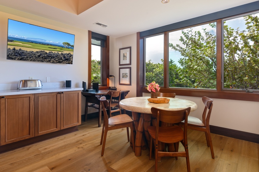Your bright kitchen nook welcomes morning coffee with tropical garden views through expansive windows.