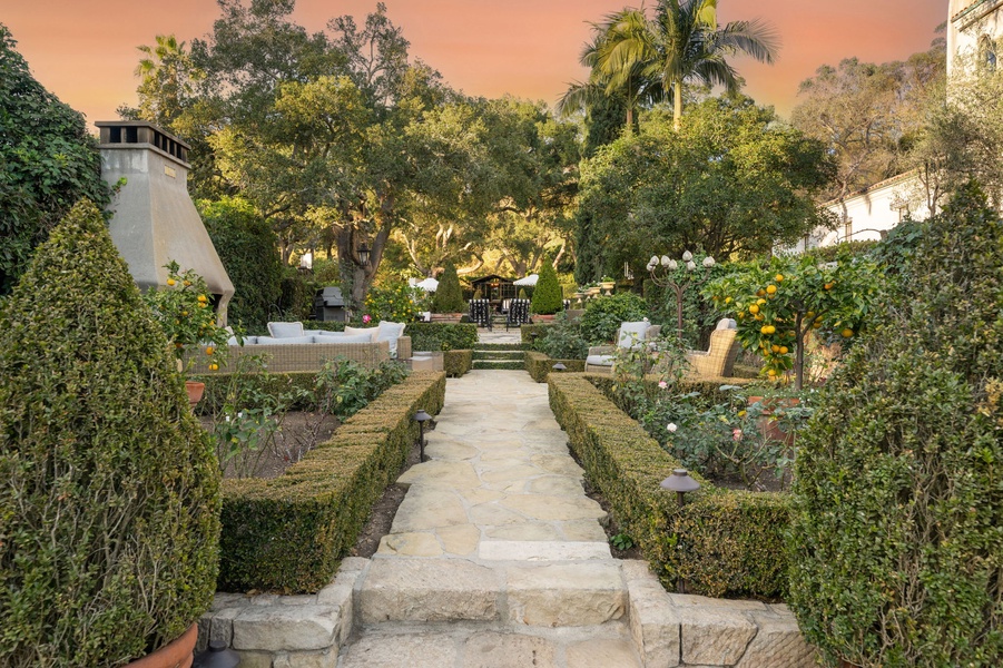 Beautifully landscaped garden with citrus trees creates a peaceful retreat beneath the warm evening sky.