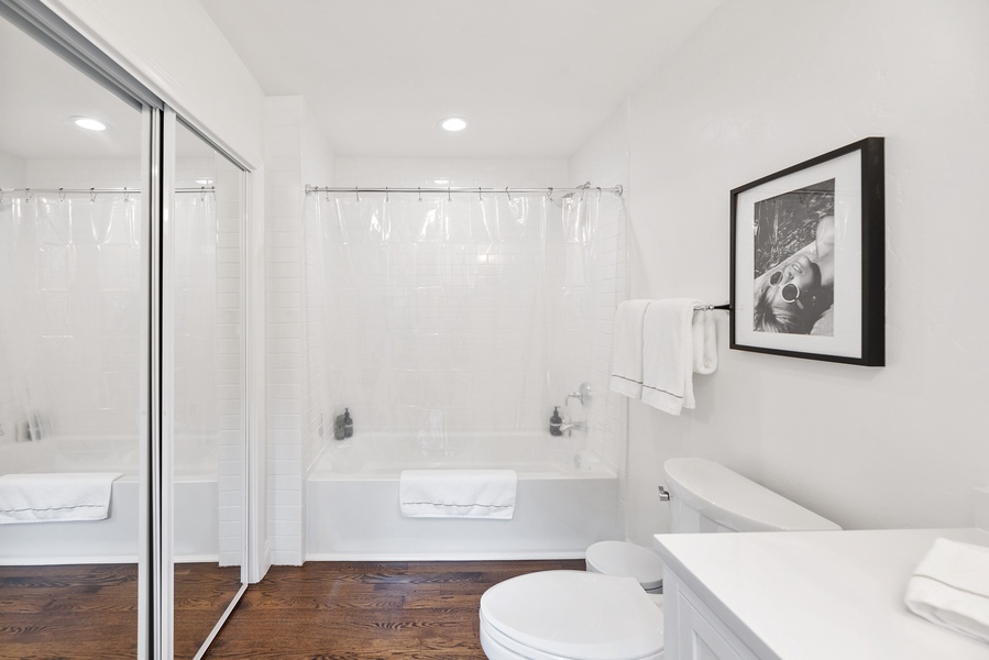 Stylish tub-shower combo with clear curtain ensures both privacy and elegance.