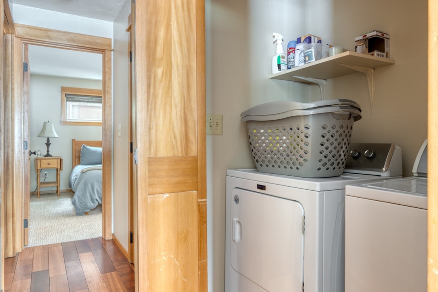 The laundry area with a washer and a dryer is conveniently located in the hallway to the guest bedroom