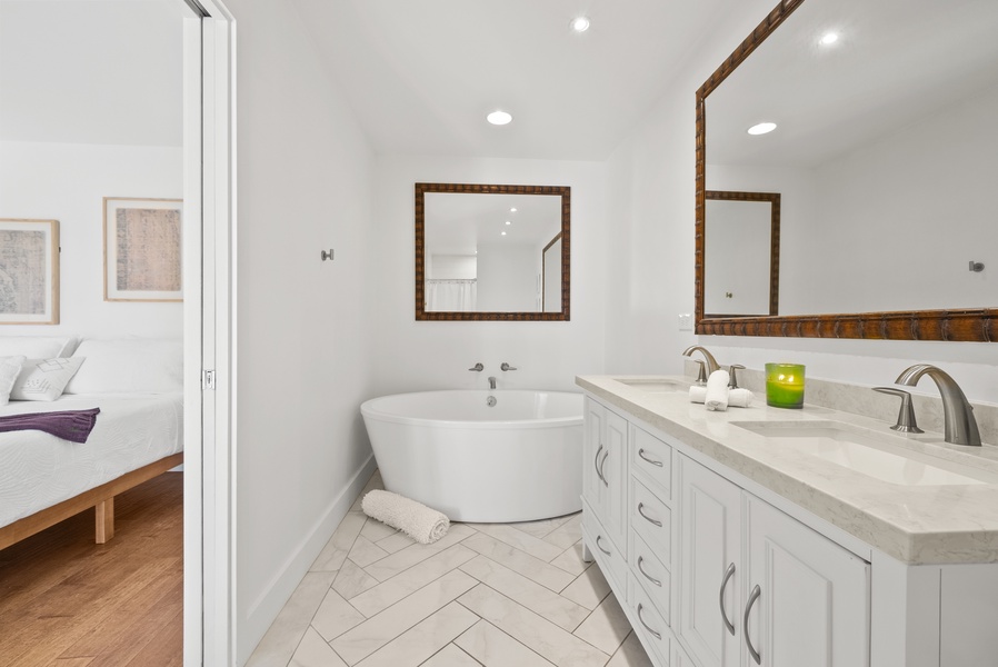 Unwind in this serene bathroom featuring a deep soaking tub and chic design.
