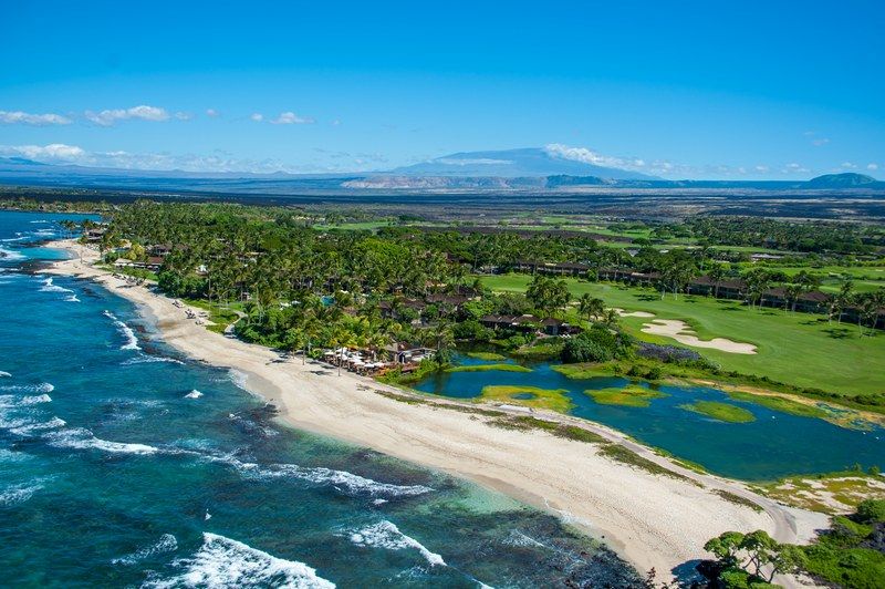 Discover the beauty of the Hualalai Resort with stunning views of the ocean and lush greens.