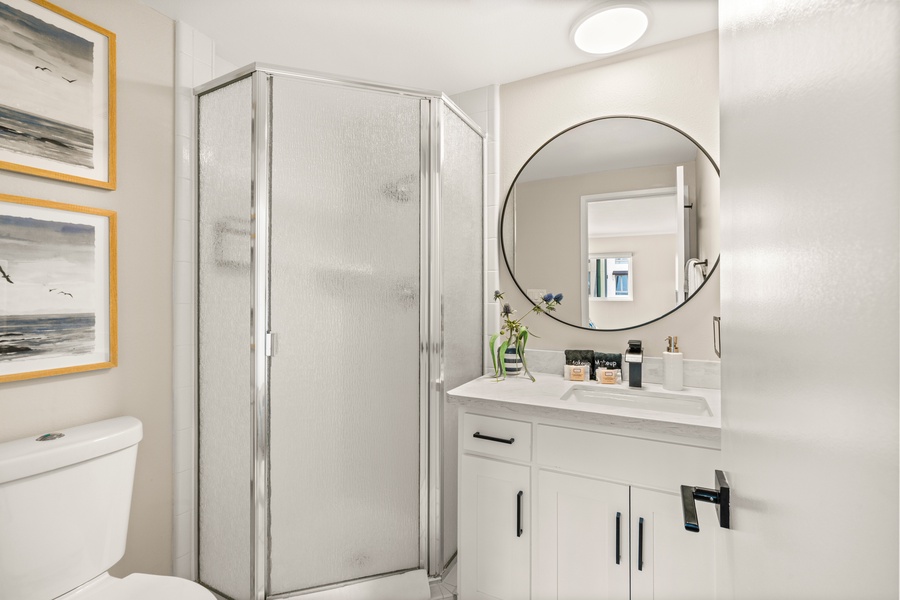 Sleek walk-in shower with modern finishes for a refreshing rinse after ocean adventures.