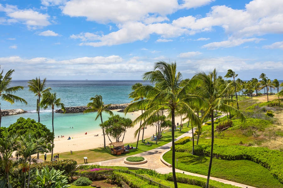 Pristine tropical paradise featuring white sand beach, turquoise waters, and swaying palm trees creating an idyllic Hawaiian escape.