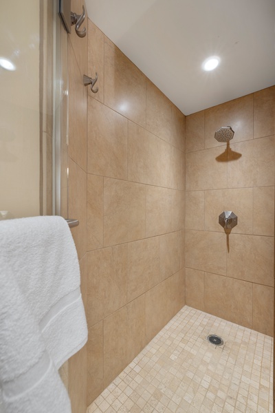 Step into a luxurious walk-in shower with rain-style fixtures and sleek tile design.