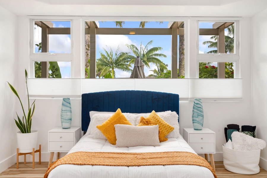 Flanked by symmetrical doorways, the room opens up to a captivating view of palm trees through a central window.