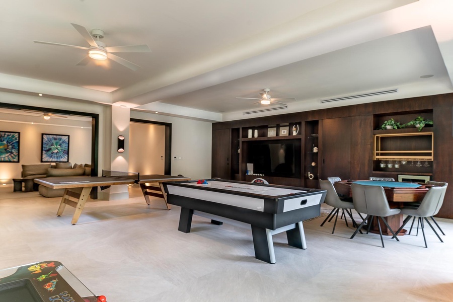 Entertain in this versatile game room with air hockey, table tennis, and comfortable seating areas.