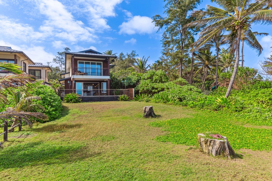 Expansive green lawn area, ideal for outdoor activities or relaxing under the tropical sun.