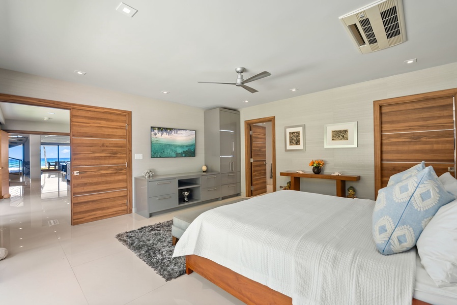 Sink into crisp linens and let the ceiling fan cool you after a day exploring. Your private retreat opens to ocean views through rich wooden doors.