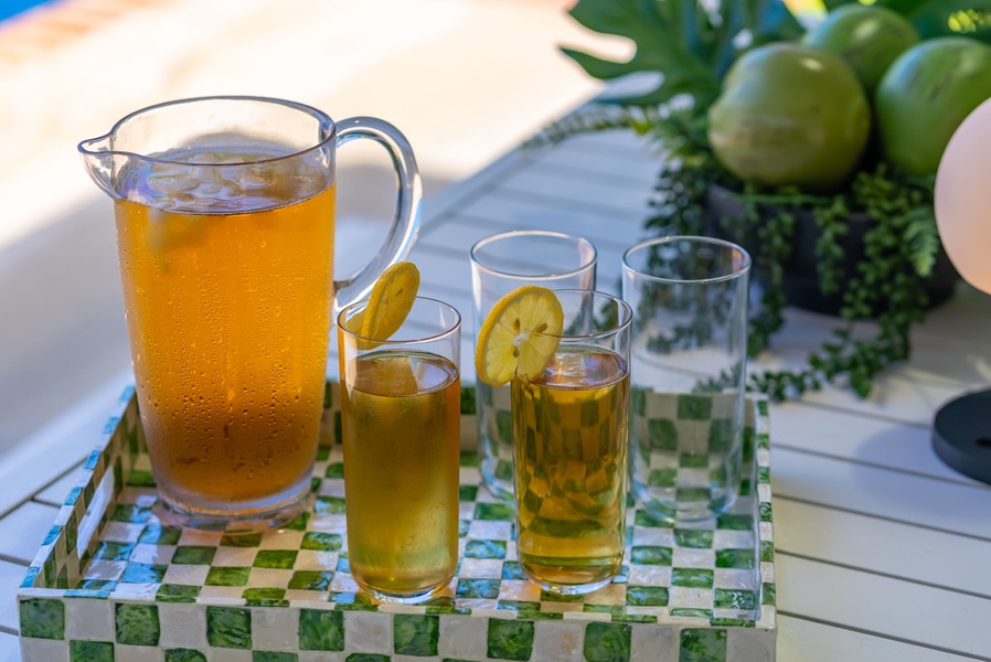 Sip chilled citrus drinks on your private terrace, surrounded by lush greenery and warm sunlight—a refreshing moment awaits you under the open sky.
