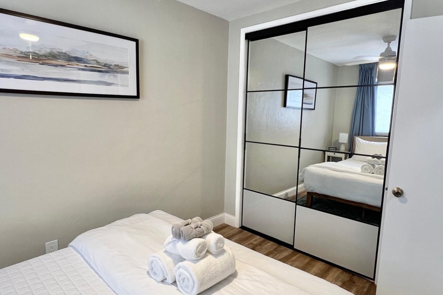 The second bedroom offers a queen-sized bed and large mirrored closet.