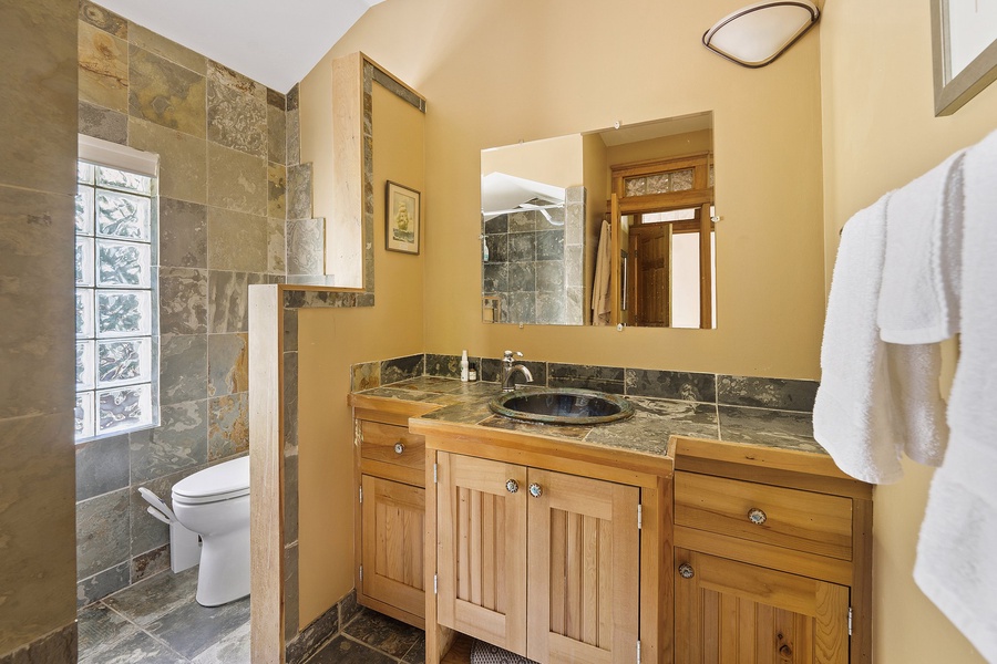 A modern bathroom with a sleek vanity and stone countertop, exuding spa-like elegance.