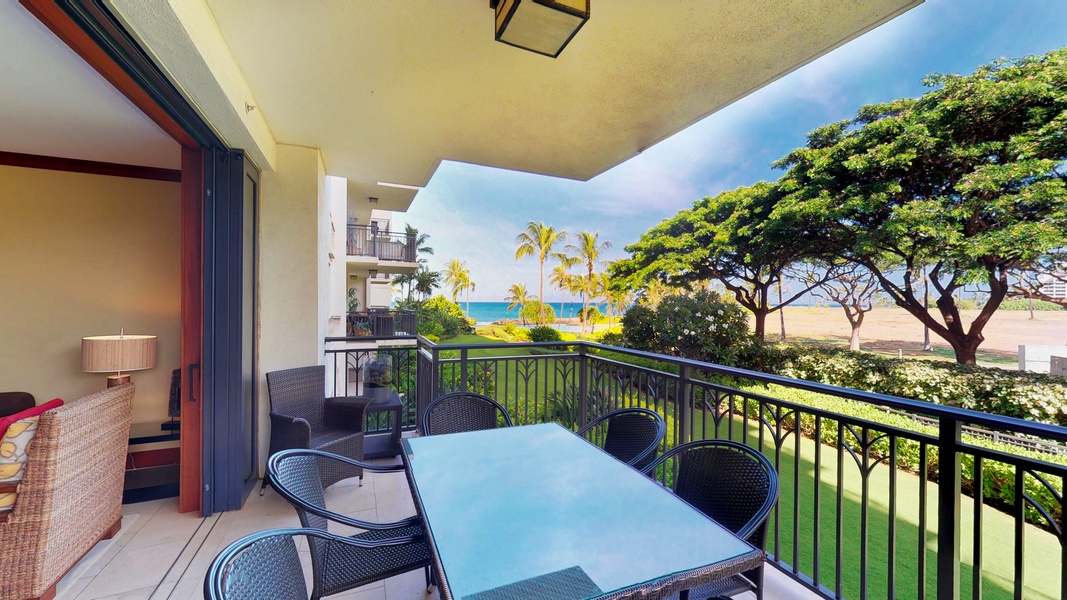 The lanai with seating and a panoramic view of gardens and the sea.