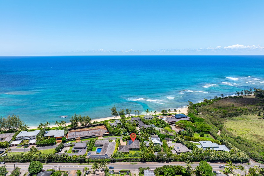 Expansive ocean view with Kaunala Retreat tucked among palms and blue horizon.