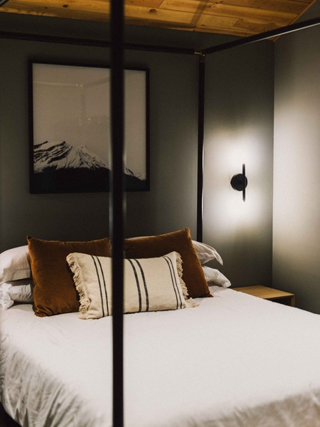 Recharge in the serene bedroom with soft lighting and modern cabin-inspired design.