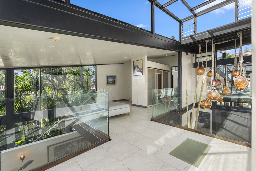 A stunning glass walkway connects the upper-level living spaces with natural light.