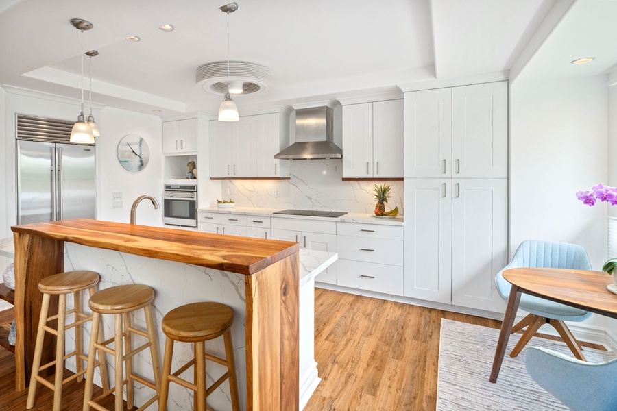 Experience a touch of luxury in this fully-equipped kitchen, featuring modern appliances, bar seating, and aesthetic decor, perfect for memorable short-term stays.