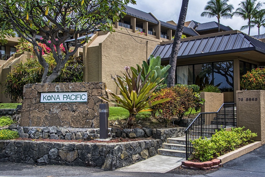 Welcoming entrance to the Kona Pacific complex surrounded by greenery