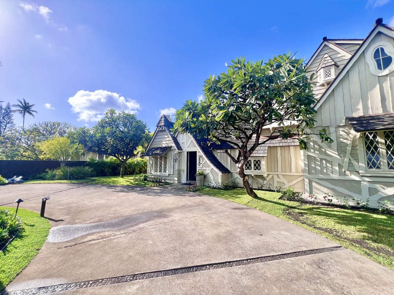 Expansive driveway leading to the estate, surrounded by manicured greenery and plenty of space for parking.