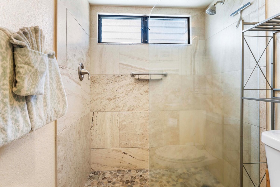 The separate walk-in shower with River-Rock base.