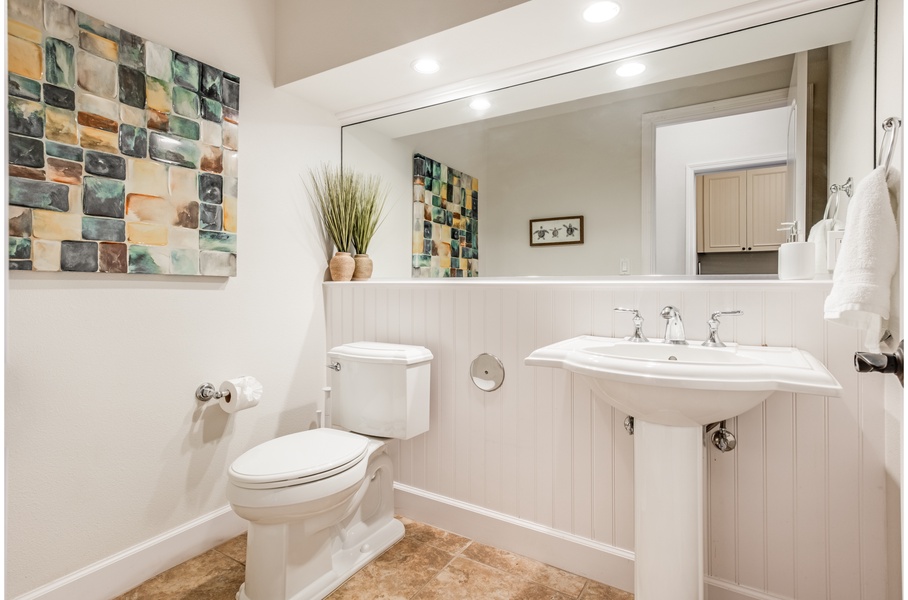 Bright and convenient powder room located downstairs next to the kitchen hallway